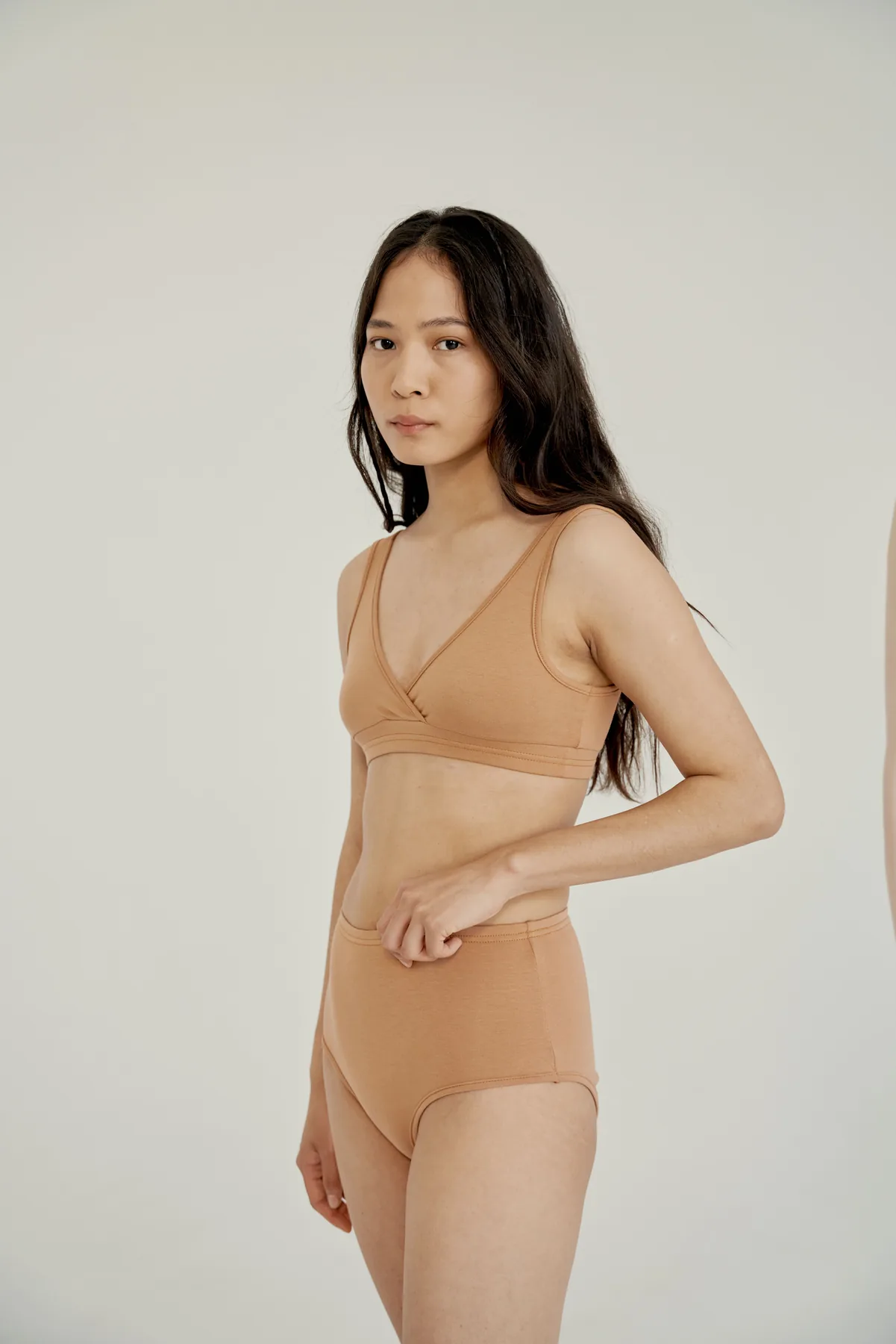 Woman wearing a neutral everyday bralette and brief set
